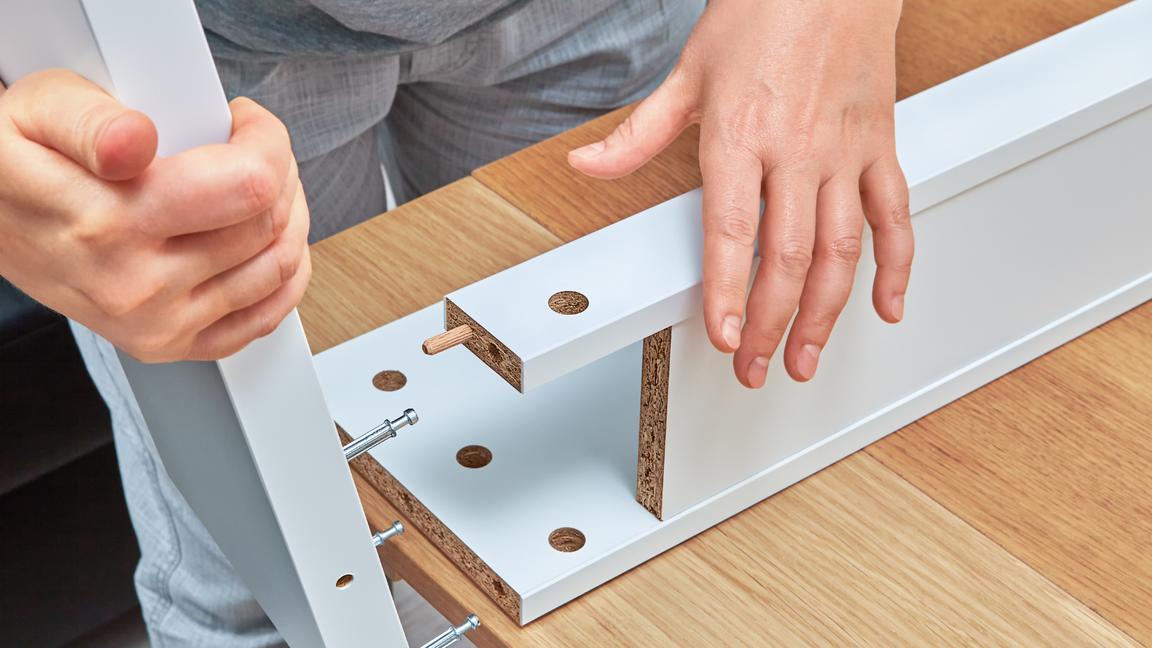 A person is holding a piece of wood in front of a door