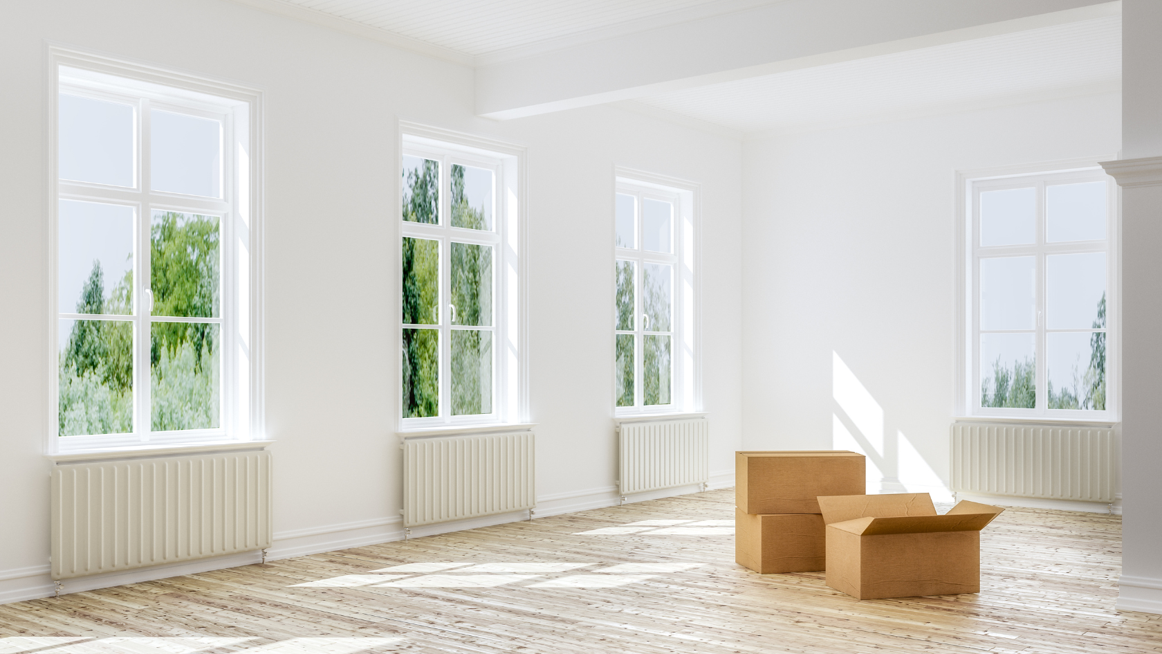 An empty room with three windows and a box on the floor