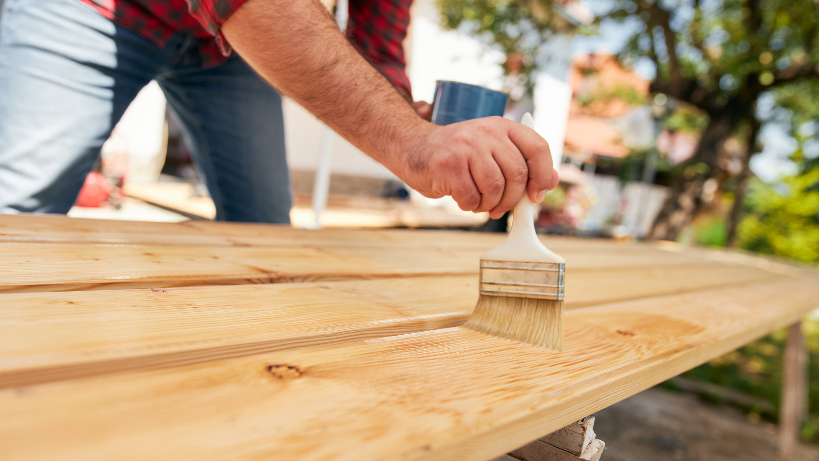 A man painting a wooden table with a brush